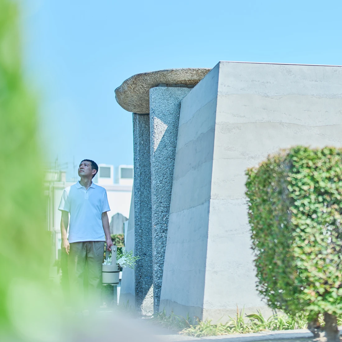 お墓参りで空を見上げる人