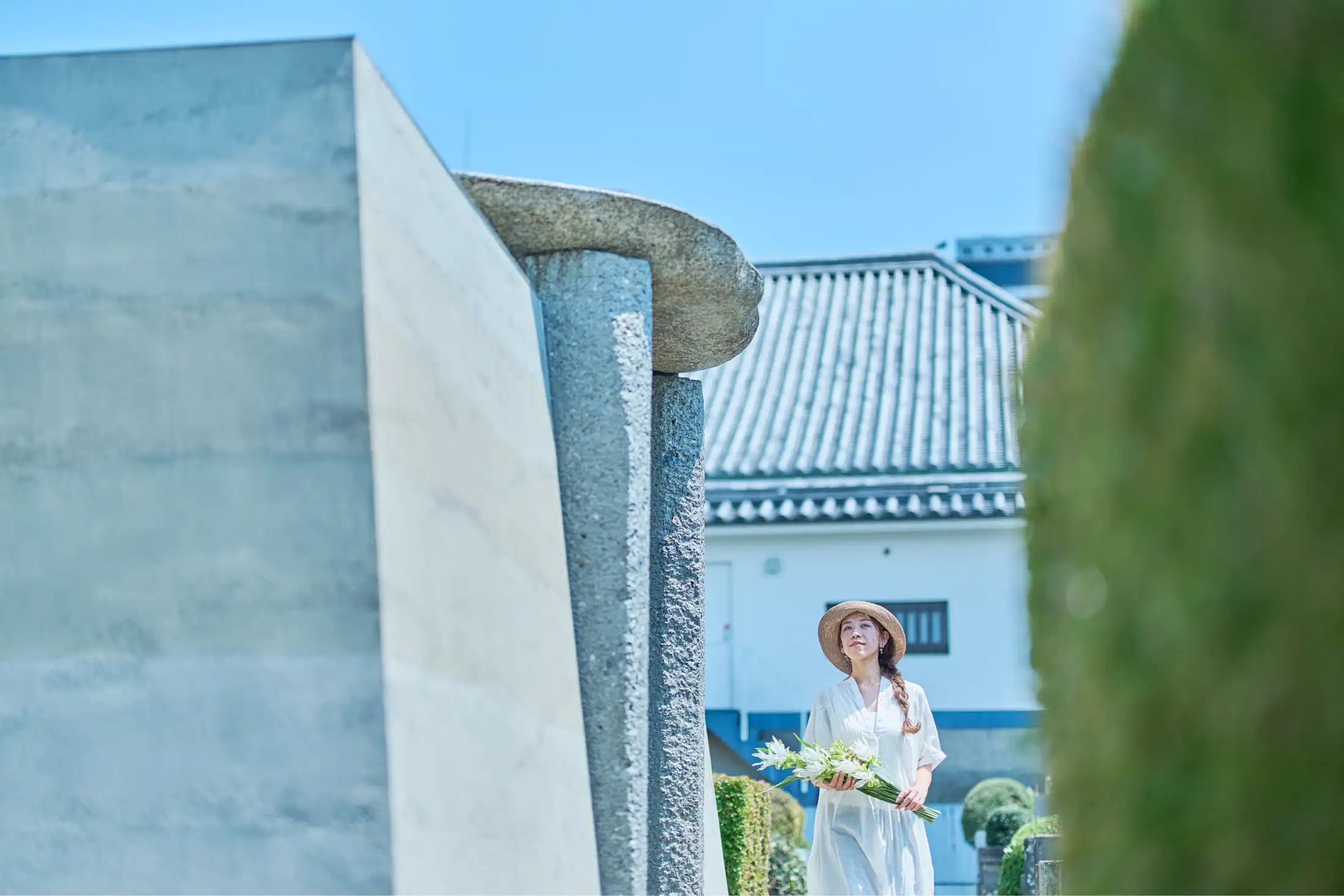 青空の下でお墓参りをする人