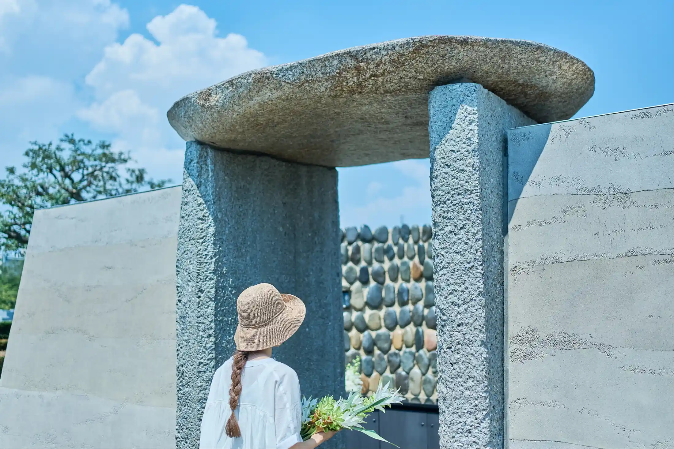 お墓参りをする人と霊園の入り口