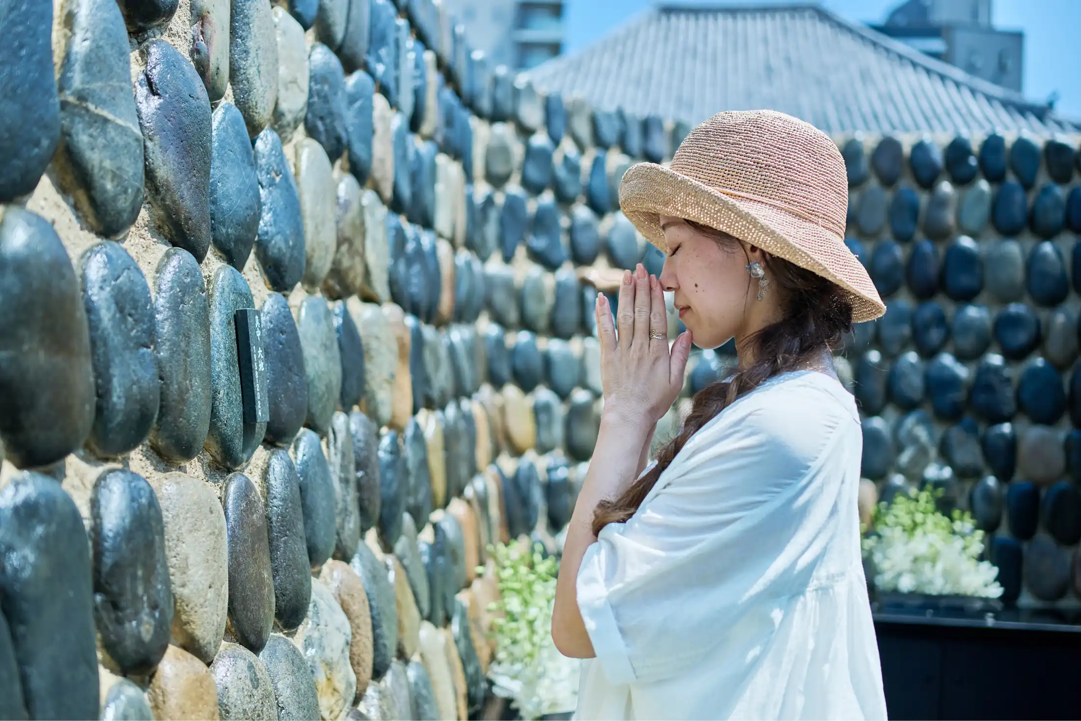 お墓で手を合わせ祈る人